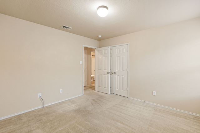 carpeted spare room with a textured ceiling