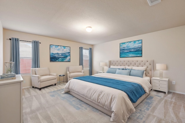 bedroom with light carpet and a textured ceiling