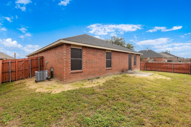 back of property featuring a patio area, a yard, and central AC