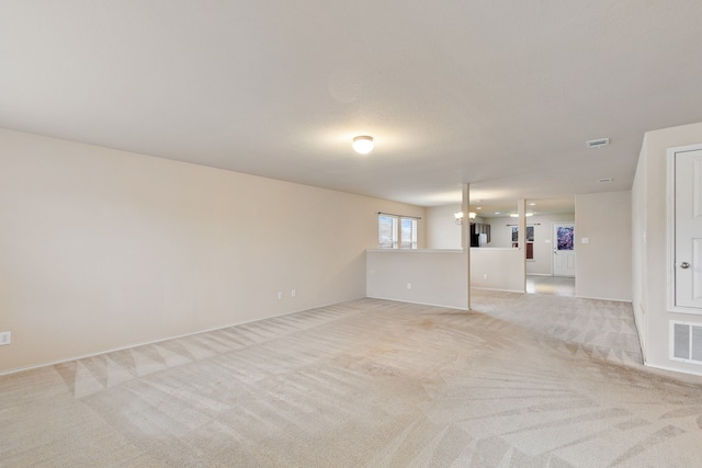 empty room with light carpet and an inviting chandelier