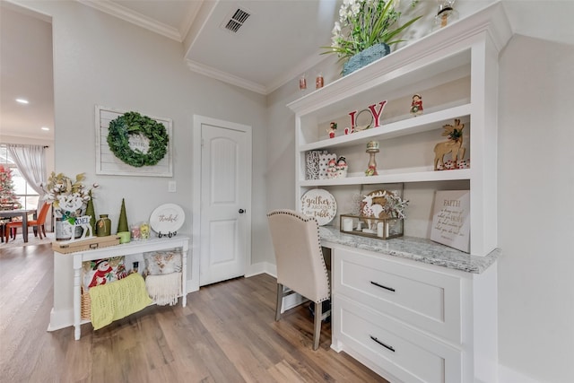 home office with light hardwood / wood-style floors and crown molding