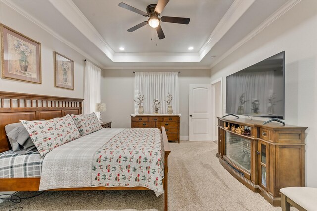 carpeted bedroom featuring ceiling fan, a raised ceiling, and ornamental molding