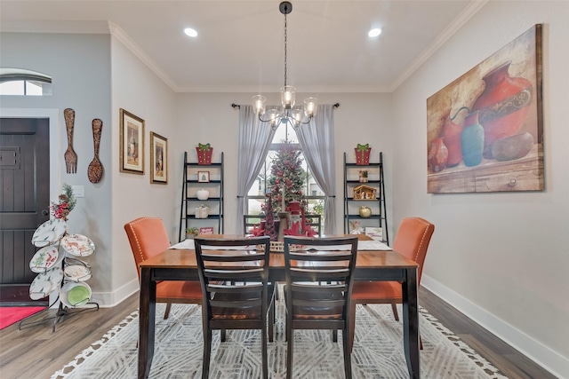 dining room with ornamental molding, a notable chandelier, and hardwood / wood-style flooring