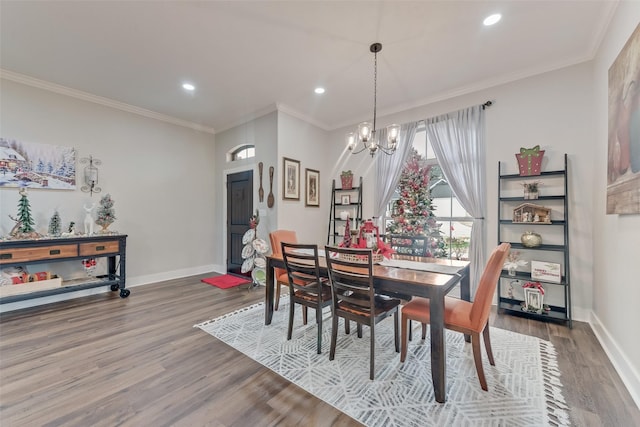 dining space featuring hardwood / wood-style flooring, ornamental molding, and a notable chandelier