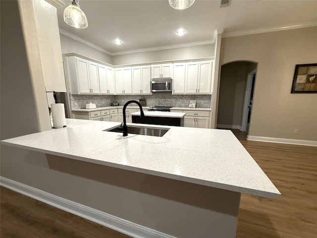 kitchen with decorative backsplash, crown molding, sink, white cabinets, and dark hardwood / wood-style floors