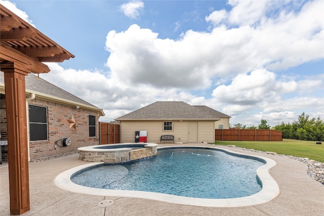 view of pool with an in ground hot tub, a yard, an outbuilding, and a patio area