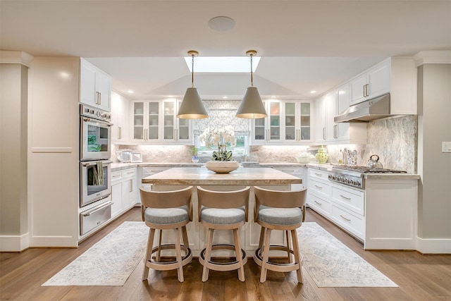 kitchen featuring white cabinetry, tasteful backsplash, appliances with stainless steel finishes, and a kitchen island