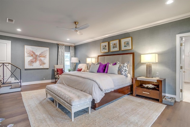 bedroom with ornamental molding, hardwood / wood-style floors, and ceiling fan