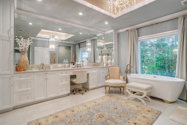 bathroom featuring a bathing tub, vanity, a tray ceiling, tile patterned floors, and an inviting chandelier