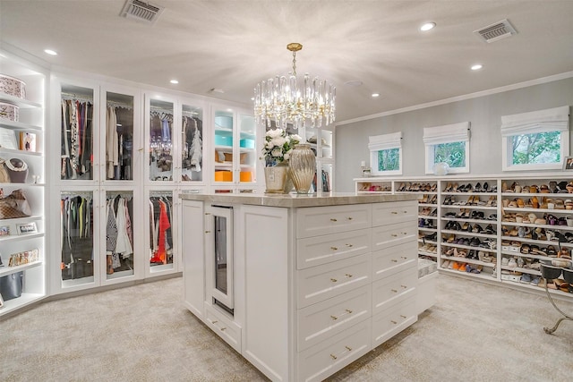 spacious closet with light carpet, a notable chandelier, and beverage cooler