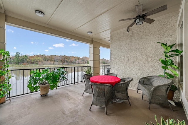 balcony featuring a water view and ceiling fan