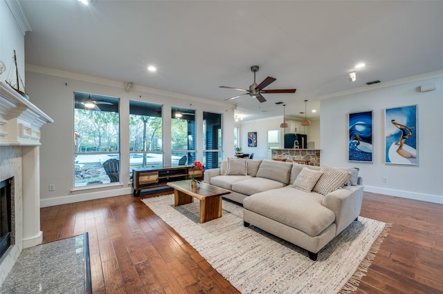 living room with a fireplace, wood-type flooring, ceiling fan, and ornamental molding