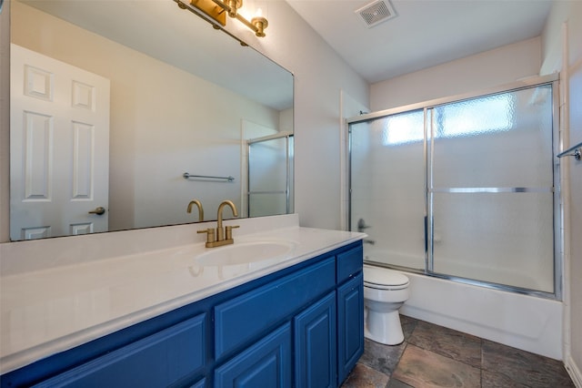 full bathroom featuring vanity, toilet, and bath / shower combo with glass door