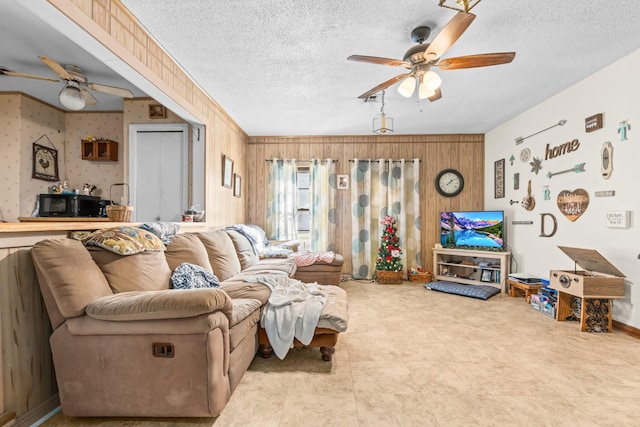 living room featuring ceiling fan and a textured ceiling