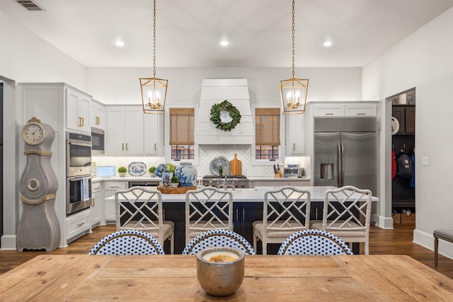 kitchen with pendant lighting, stainless steel appliances, a kitchen breakfast bar, and a center island