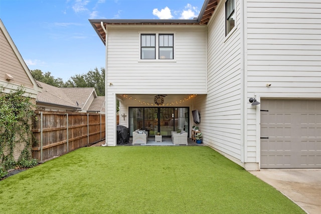 back of house featuring a yard and a garage