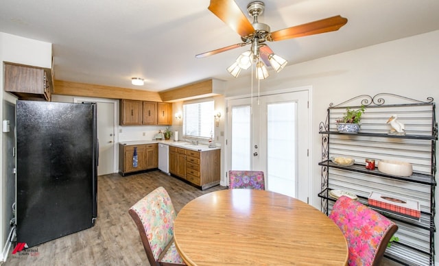 dining area featuring sink, hardwood / wood-style floors, ceiling fan, and french doors