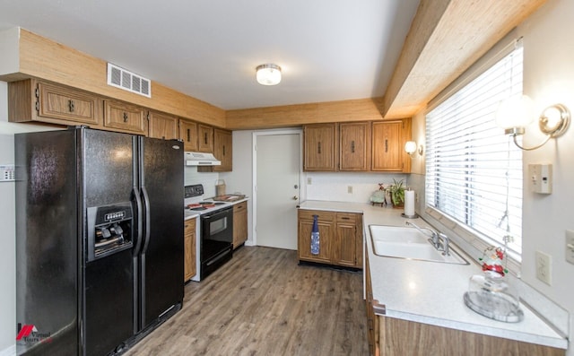 kitchen featuring wood-type flooring, sink, and black appliances