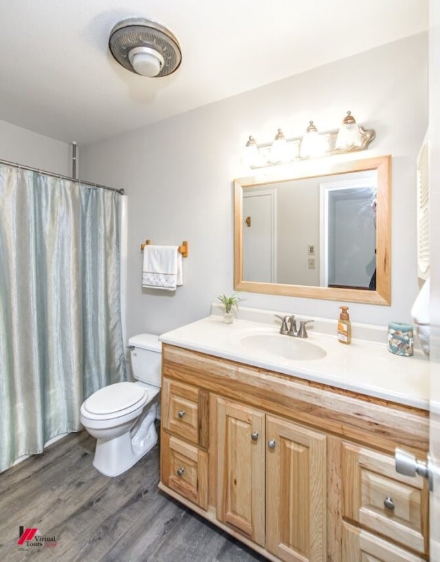 bathroom with vanity, toilet, and wood-type flooring