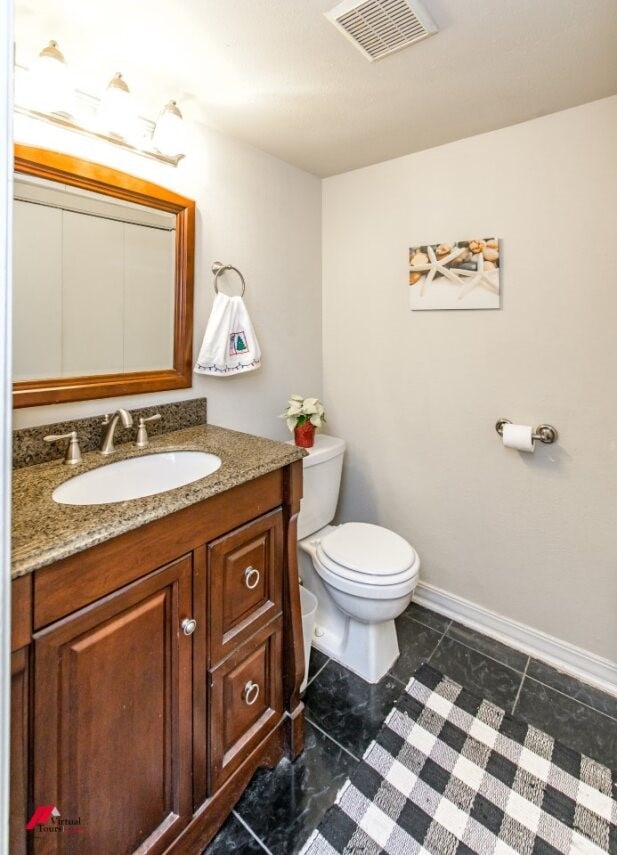 bathroom featuring tile patterned flooring, vanity, and toilet