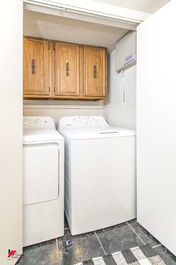 washroom with cabinets and washer and clothes dryer