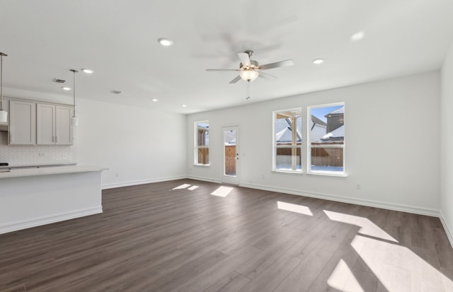 unfurnished living room with ceiling fan and dark hardwood / wood-style flooring