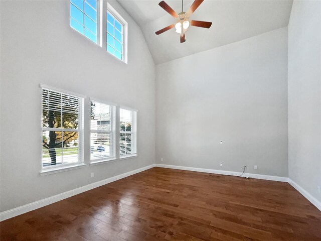 empty room with ceiling fan, high vaulted ceiling, and dark wood-type flooring