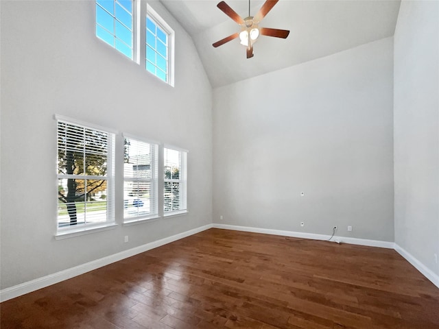 empty room featuring dark hardwood / wood-style flooring, high vaulted ceiling, and ceiling fan