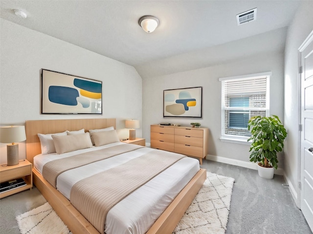 bedroom with light colored carpet and vaulted ceiling