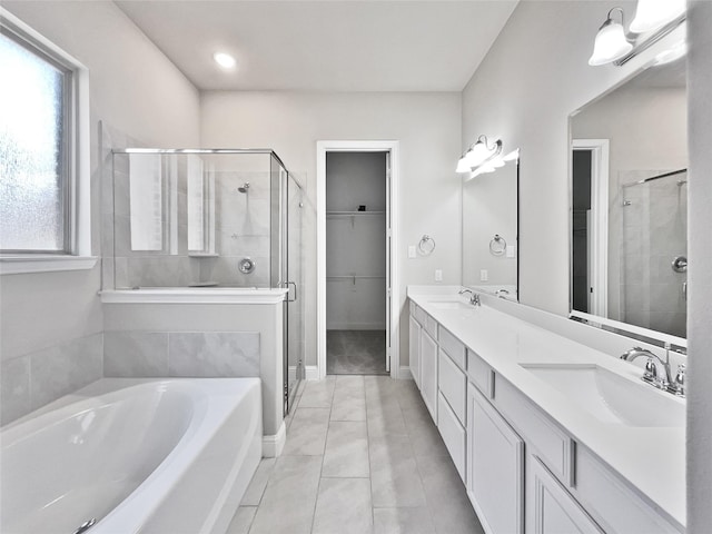 bathroom featuring tile patterned floors, vanity, and shower with separate bathtub