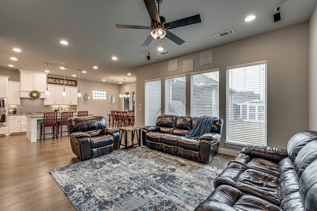 living room featuring ceiling fan and hardwood / wood-style flooring