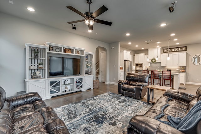 living room with ceiling fan and dark hardwood / wood-style flooring