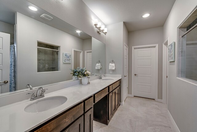 bathroom with vanity, a textured ceiling, and walk in shower