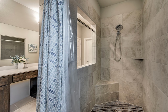 bathroom featuring tile patterned floors, vanity, and tiled shower