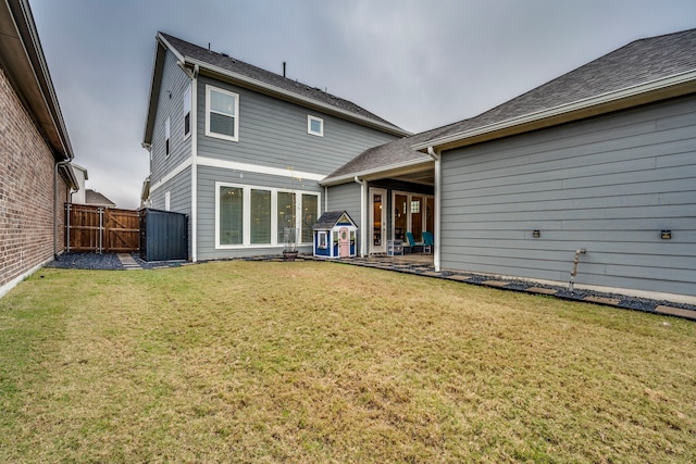 rear view of property with a patio and a lawn