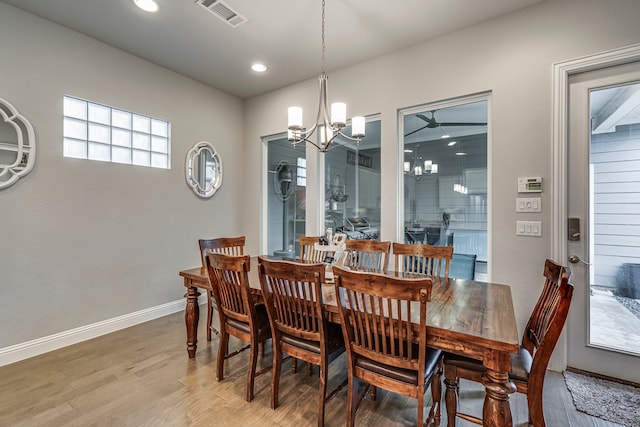 dining room with wood-type flooring and an inviting chandelier