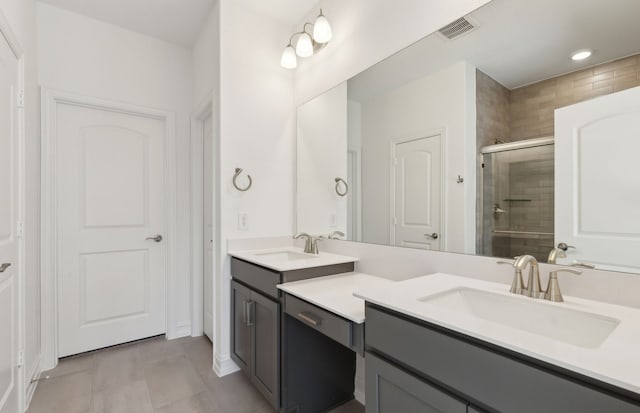 bathroom featuring tile patterned flooring, vanity, and a shower with shower door