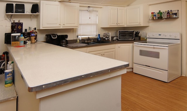 kitchen featuring sink, light hardwood / wood-style floors, white cabinets, and white range with electric cooktop