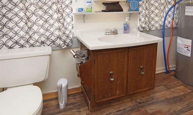 bathroom with hardwood / wood-style floors, vanity, electric water heater, and toilet