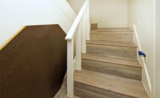 stairs featuring hardwood / wood-style floors