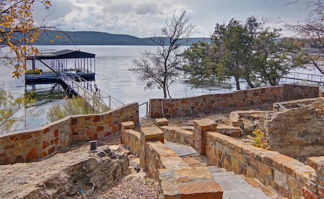 view of yard with a water and mountain view and a dock