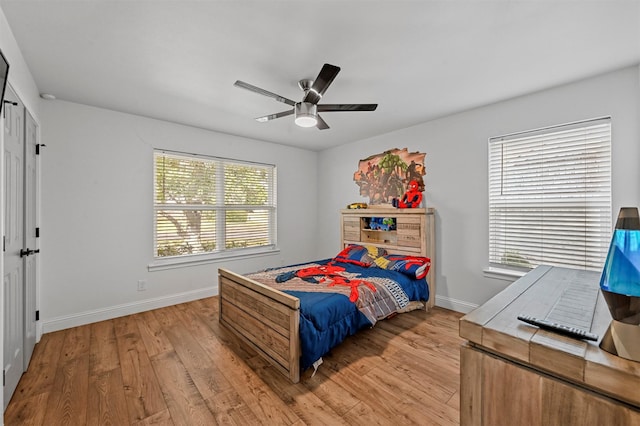 bedroom with multiple windows, ceiling fan, and light wood-type flooring