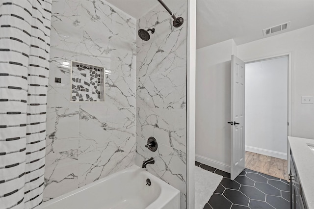 bathroom featuring tile patterned floors, vanity, and tiled shower / bath