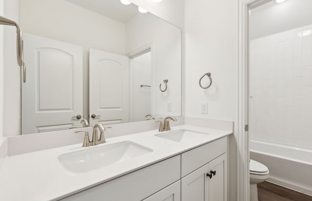 full bathroom with bathtub / shower combination, wood-type flooring, toilet, and vanity