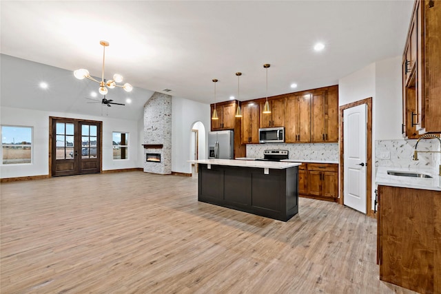 kitchen featuring a center island, light hardwood / wood-style floors, pendant lighting, a breakfast bar area, and appliances with stainless steel finishes