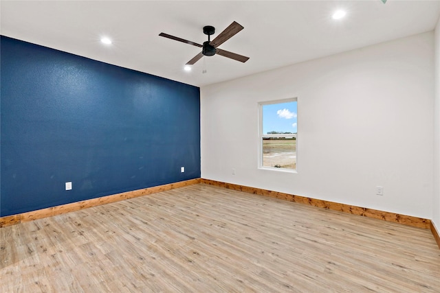 spare room with ceiling fan and light wood-type flooring