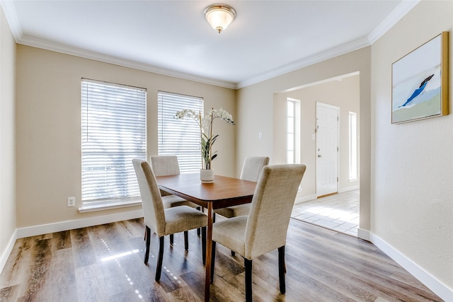 dining space featuring crown molding and light wood-type flooring