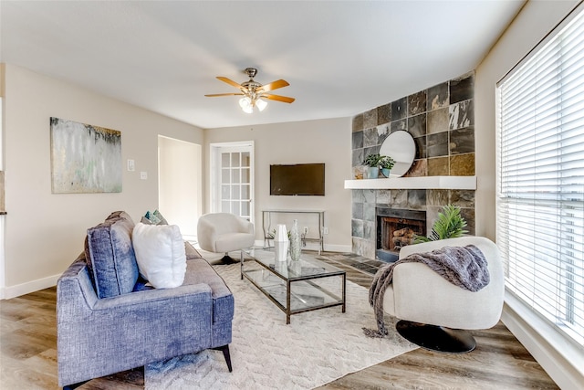 living room with a fireplace, wood-type flooring, and a healthy amount of sunlight