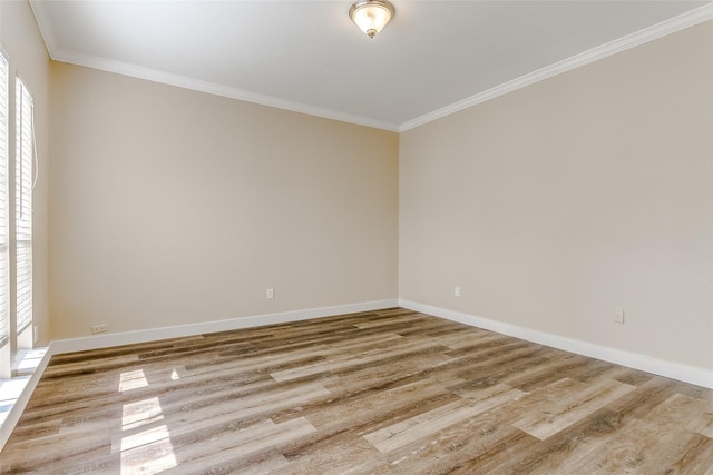 spare room featuring crown molding and light hardwood / wood-style floors