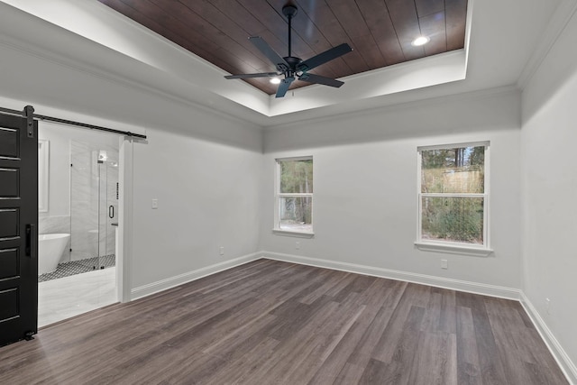 spare room featuring a barn door, a raised ceiling, hardwood / wood-style floors, and wooden ceiling